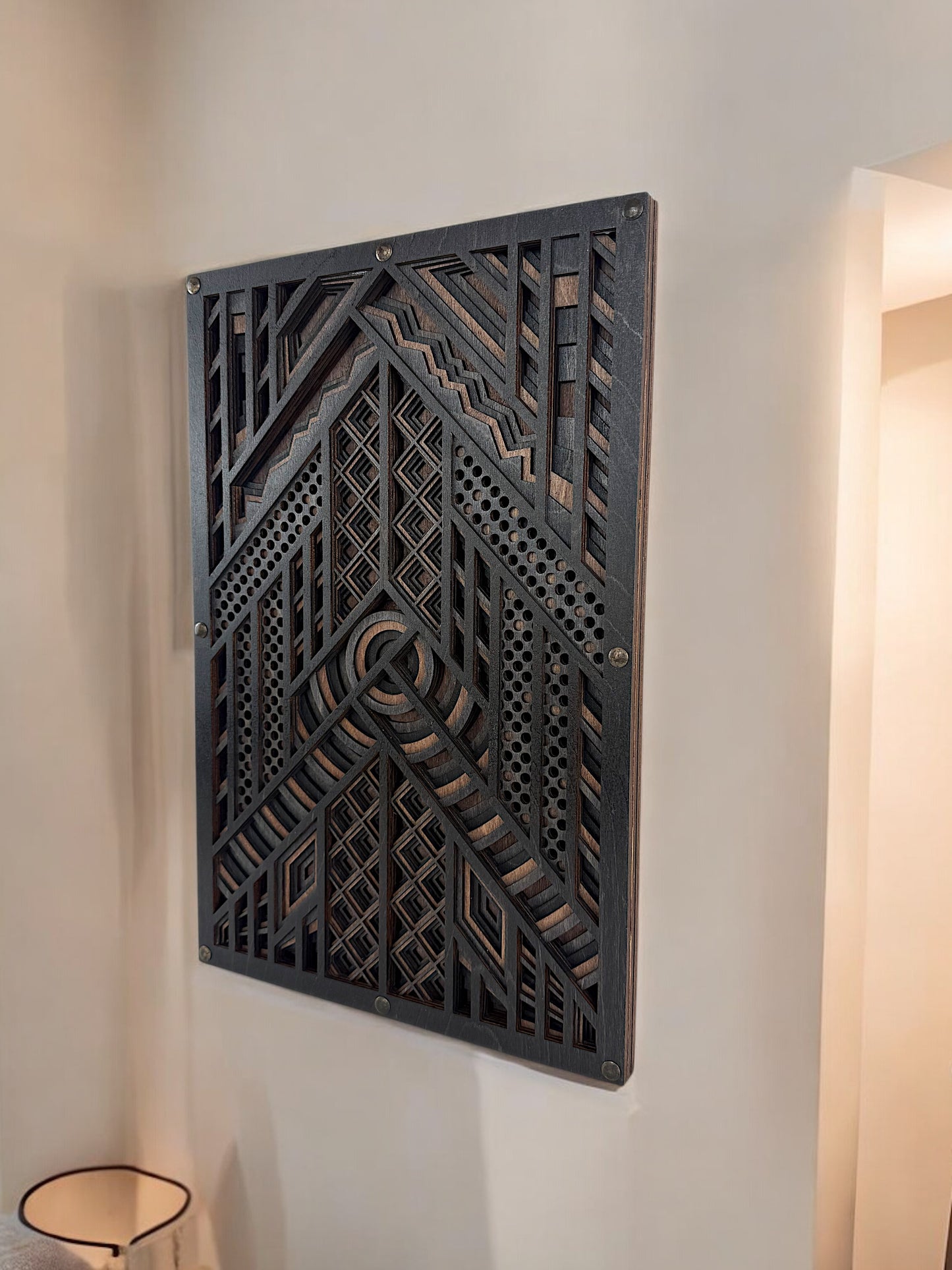Laser-cut geometric wood wall art mounted on a beige wall in a modern home interior.