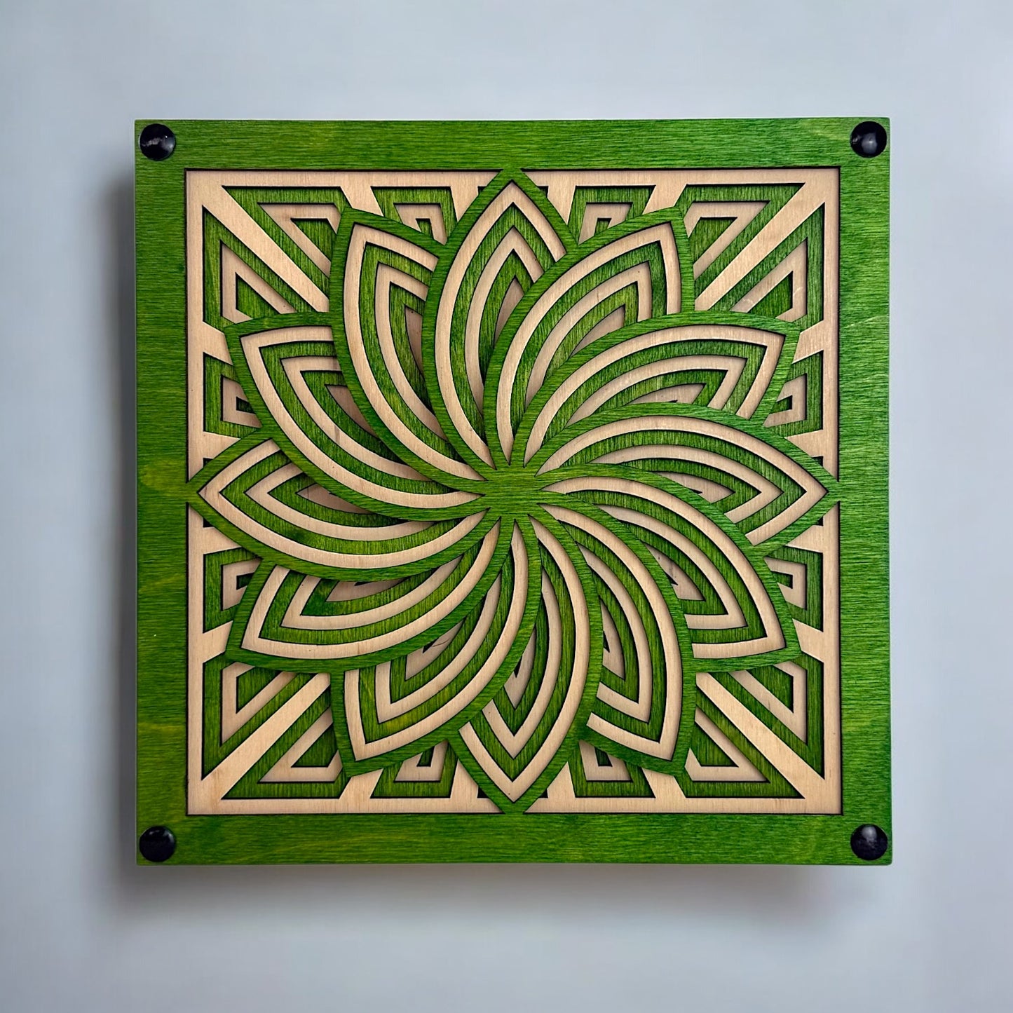Front view of Floraspiral laser-cut wood sculpture featuring layered geometric floral patterns in green and natural birch.
