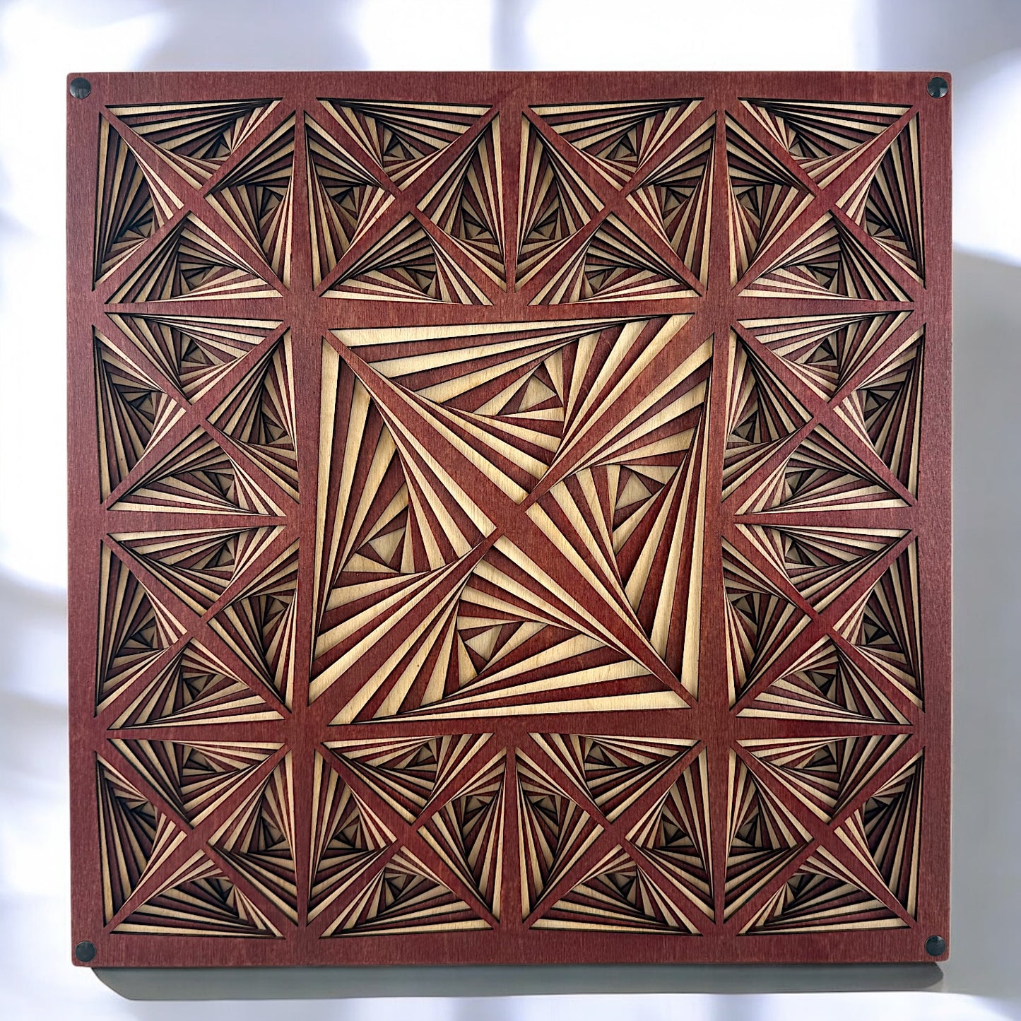Front view of a 10-layer laser-cut wood artwork featuring a hypnotic triangular geometric pattern in natural and reddish wood tones.