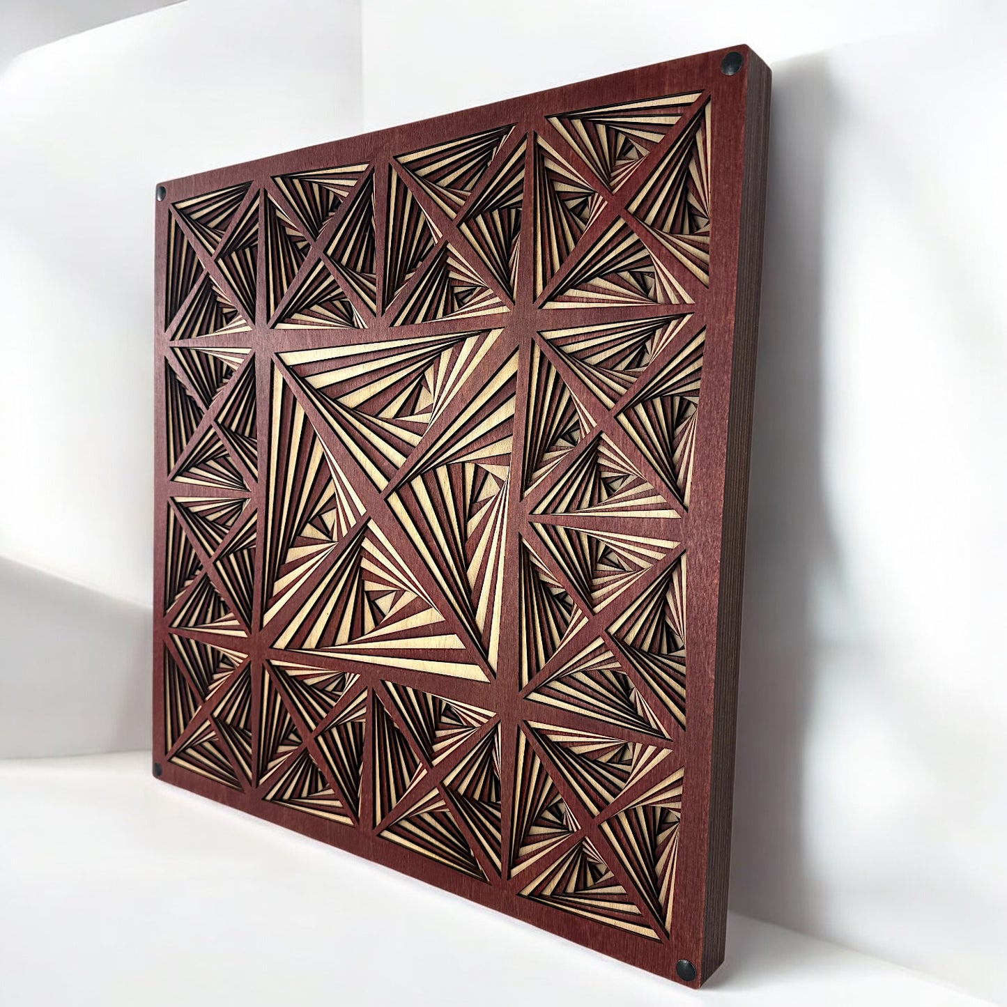Diagonal perspective showing the full layered structure of the artwork and the contrast between light and dark wood cuts.
