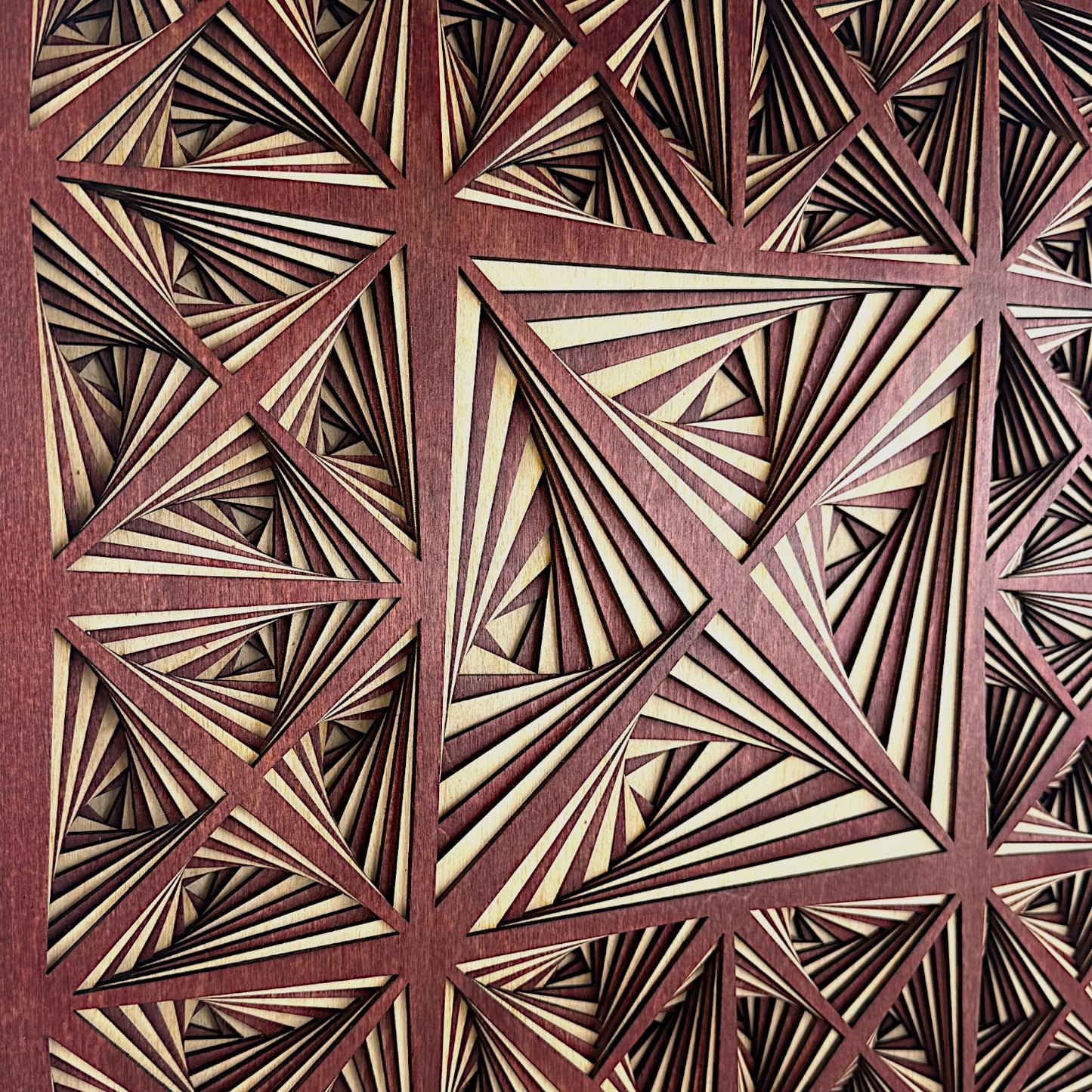 Tight detail of the artwork’s left-center section, capturing the precision, sharp angles, and interplay of shadows across the layers.