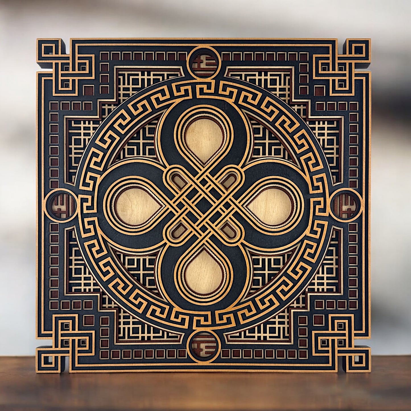 Straight-on display of the artwork placed on a wooden surface, highlighting its symmetrical balance and interwoven centerpiece.