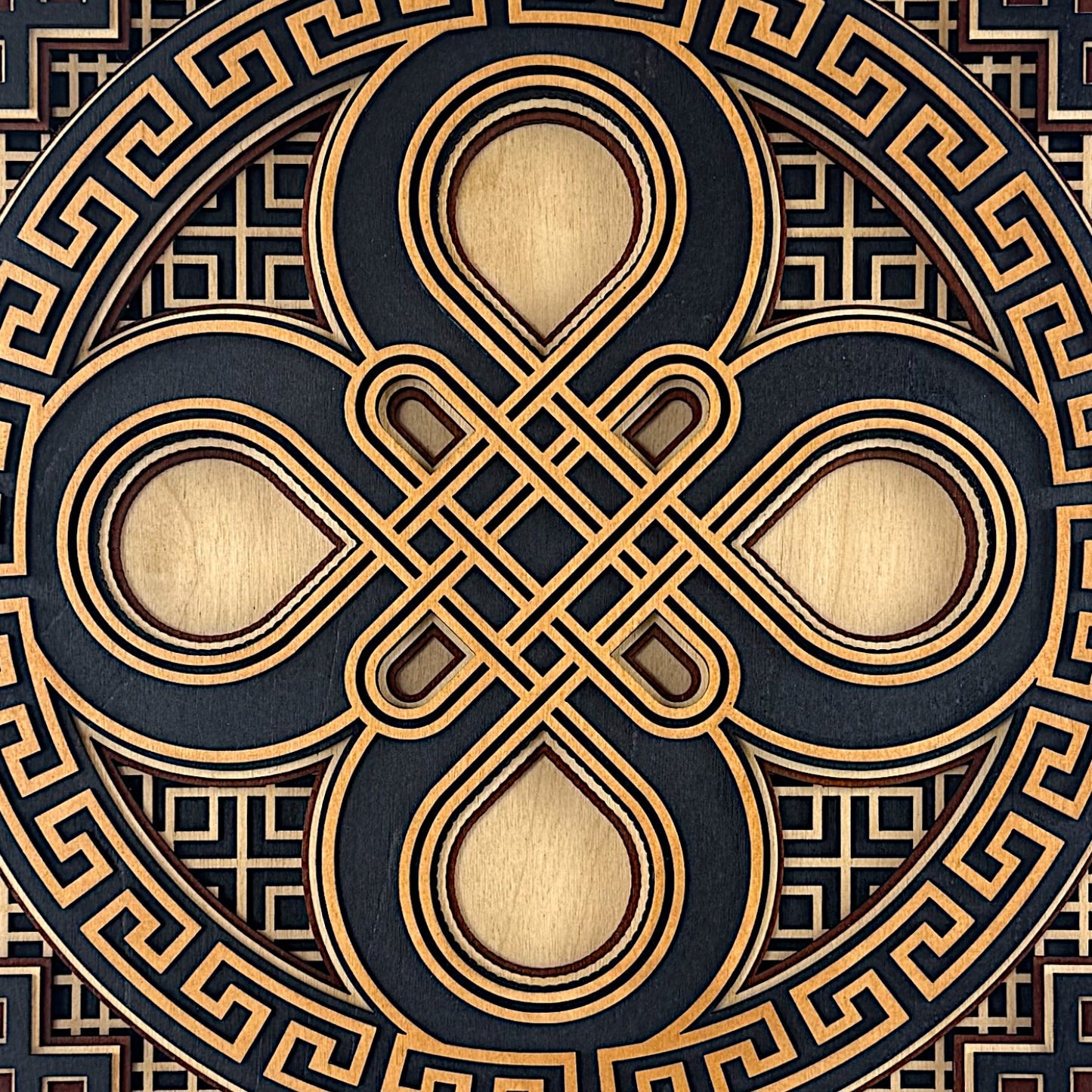 Close-up of the top section, showcasing the interlocking loops of the central knot and fine laser-etched line work.