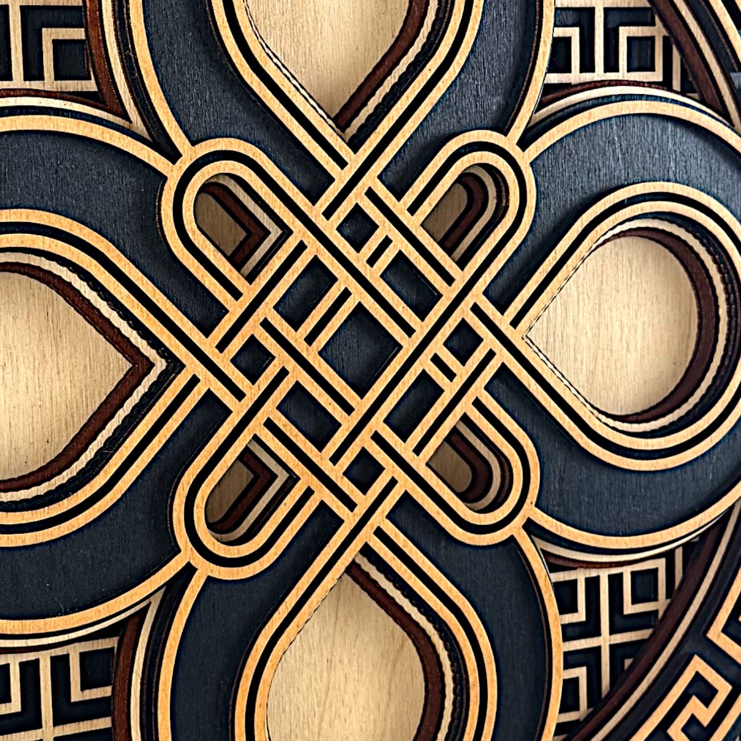 Macro detail of the center knot showing tight precision in the interlaced curves and layered wood craftsmanship.