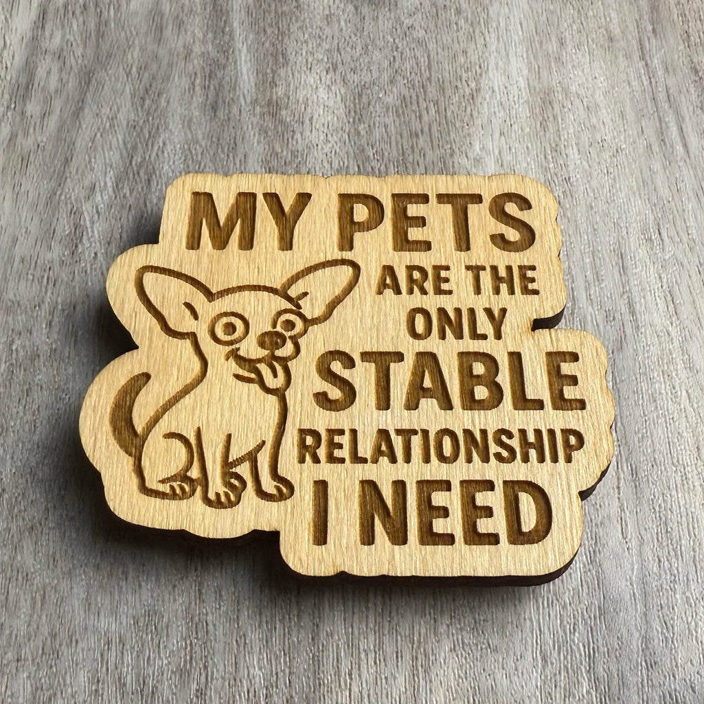 Angled view of the same engraved magnet with the Chihuahua design and the phrase “MY PETS ARE THE ONLY STABLE RELATIONSHIP I NEED.” The lighting highlights the engraved line work, especially around the cartoonishly expressive dog.
