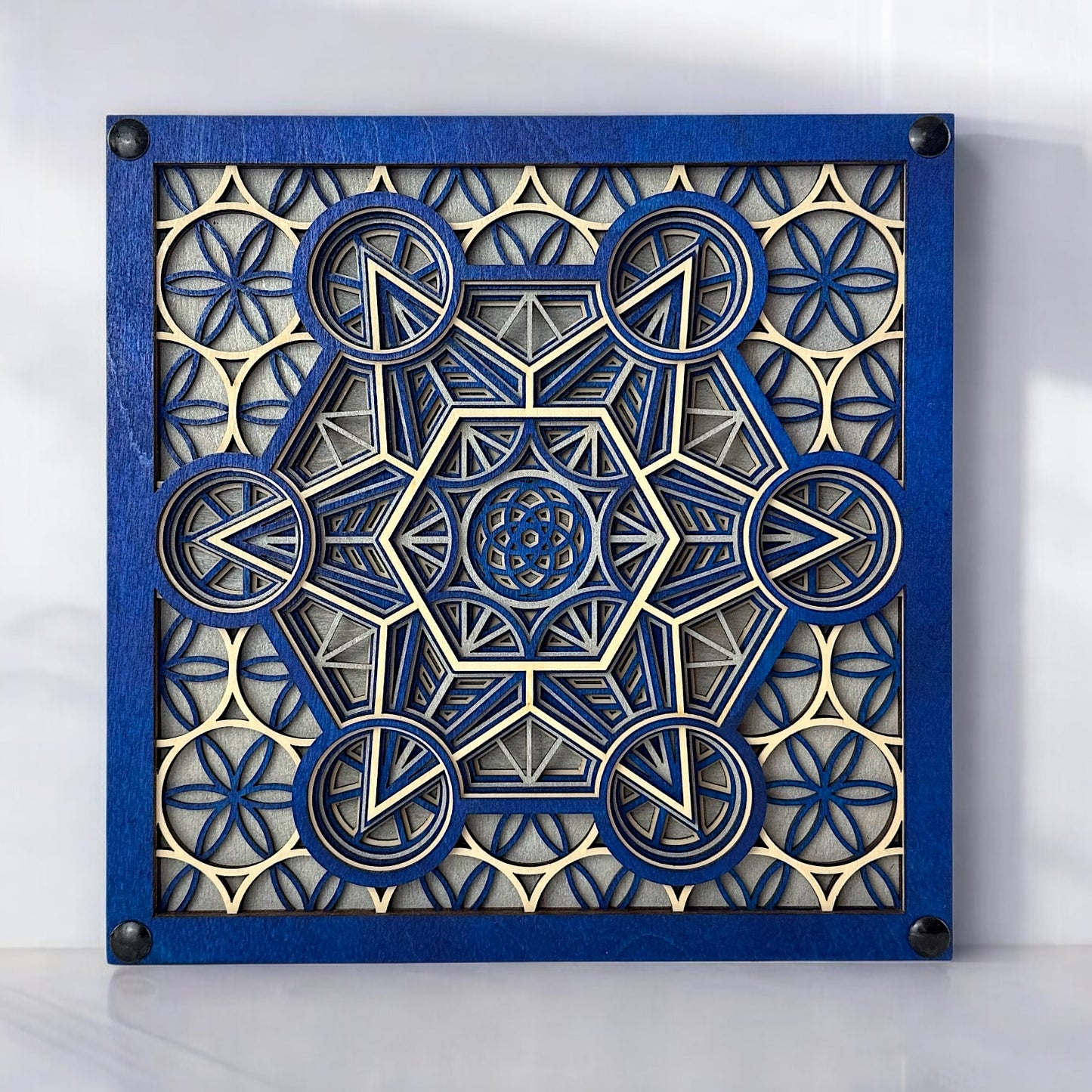 Front-facing view of "Metatron Ascend" – a blue, silver, and natural wood layered geometric art piece featuring sacred geometry and floral patterns.