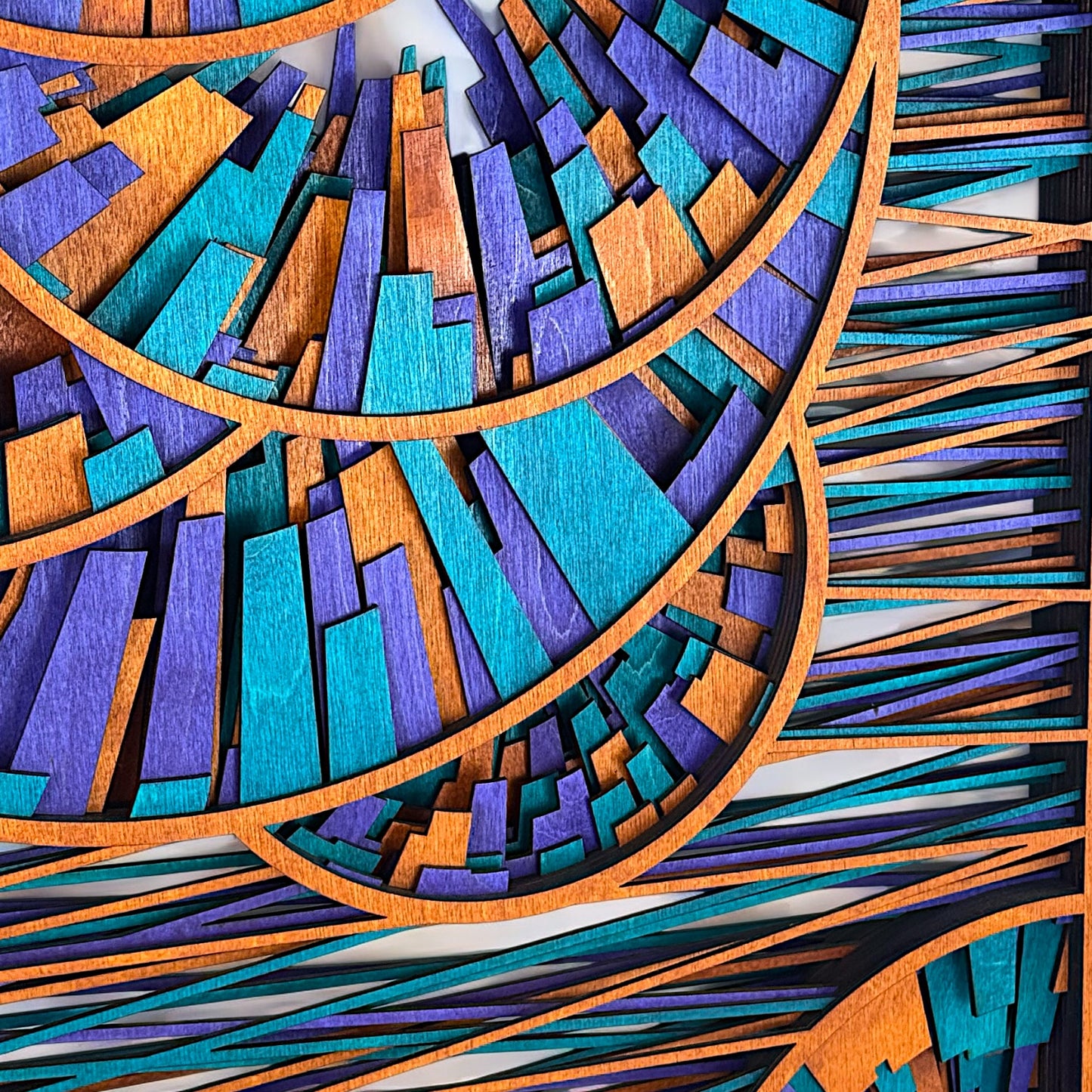Close-up detail of the central spiral section of the art, emphasizing the sharp geometric layering and texture of the stained wood in turquoise, amethyst, and amber hues.