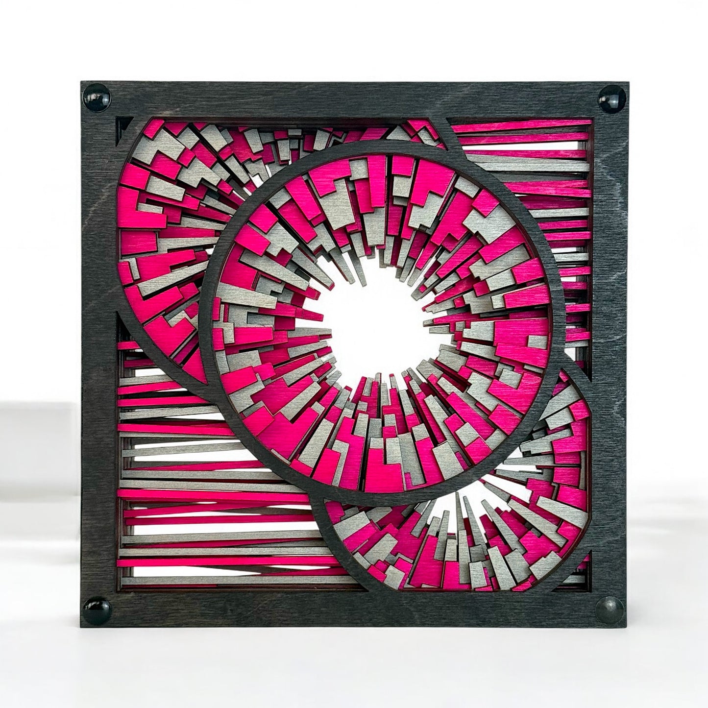 Front-facing view of Metrorhythm V2 sculpture in magenta and silver, featuring layered circular bursts and geometric lines.