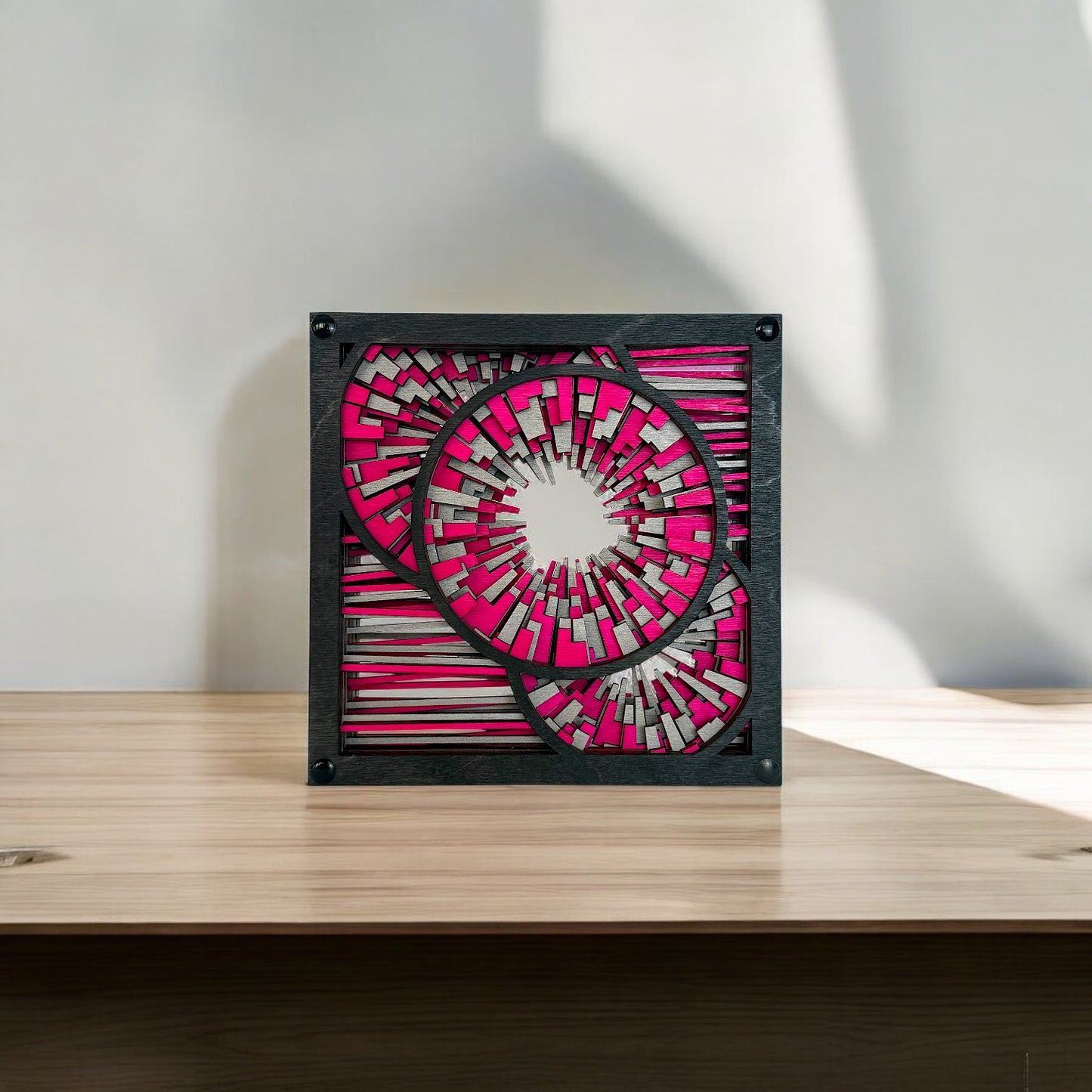 Metrorhythm V2 placed on a wooden surface with natural light casting shadows, enhancing its dimensional geometry.