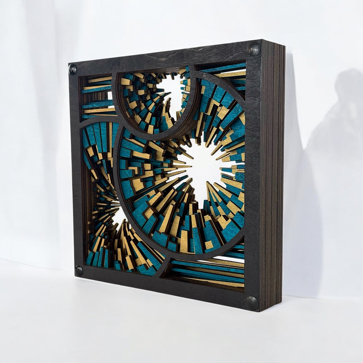 Freestanding wood sculpture viewed from the right side, showing stacked birch layers with vivid turquoise and shimmering gold.