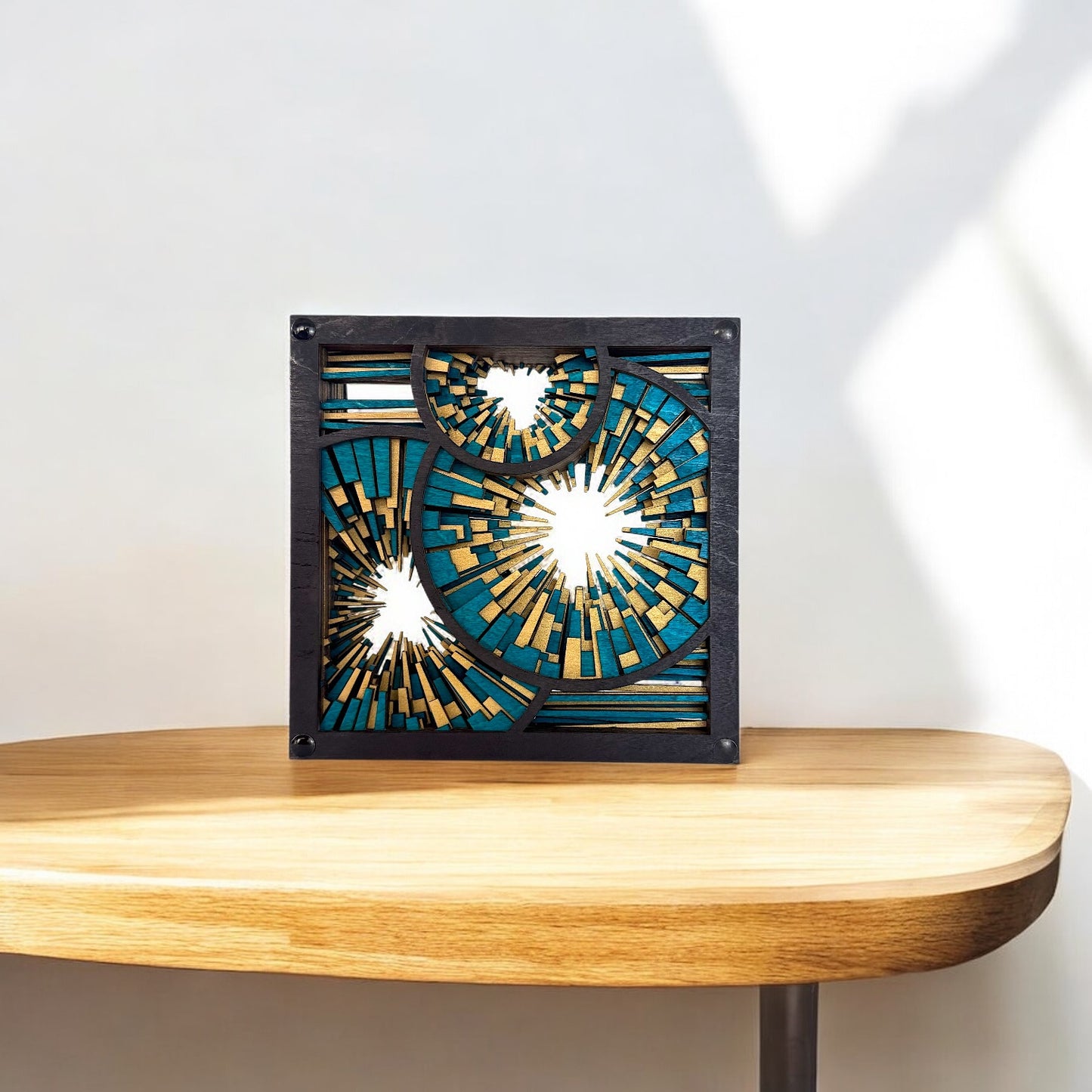 Metrorhythm V3 sculpture on a wooden shelf, catching sunlight to reveal its intricate cuts and glowing color palette.
