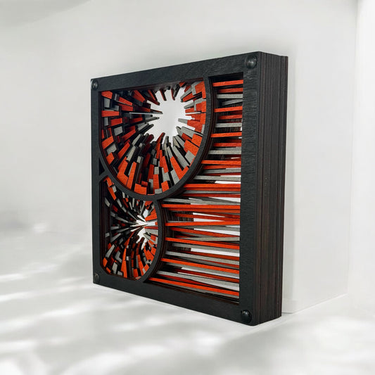Side angle of layered wood art showing depth and precision-cut edges in vibrant orange, silver, and dark wood tones.