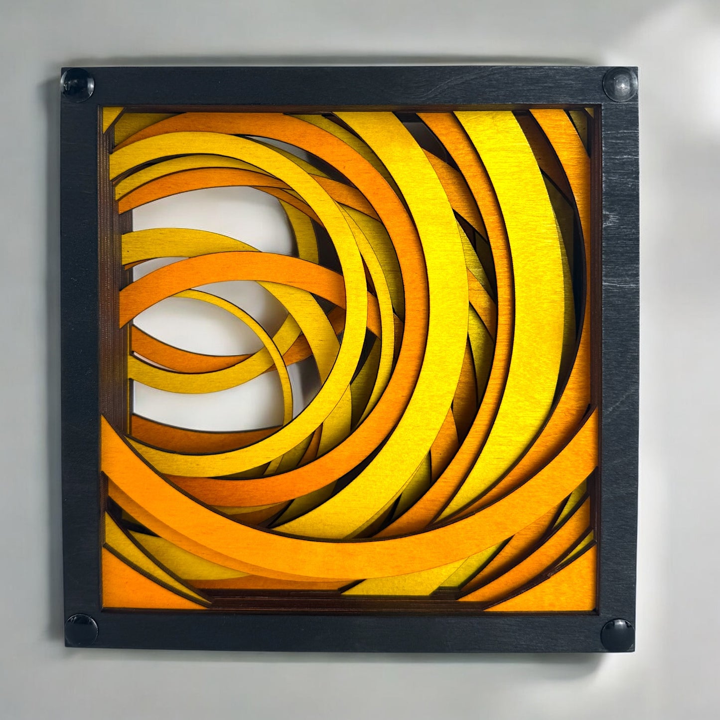Front view of Radiant Drift wall art featuring bold, layered arcs in glowing shades of yellow and orange, laser-cut into stained wood.