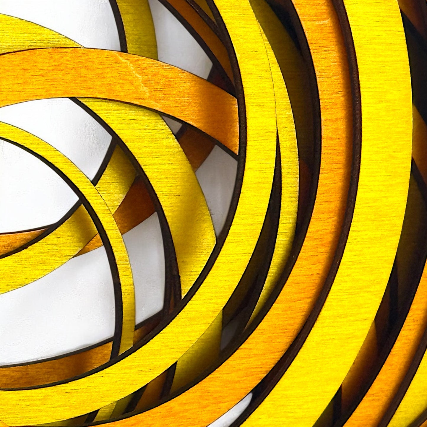Extreme close-up of Radiant Drift art piece showing the fine texture of layered stained wood in bright yellow and deep orange tones.