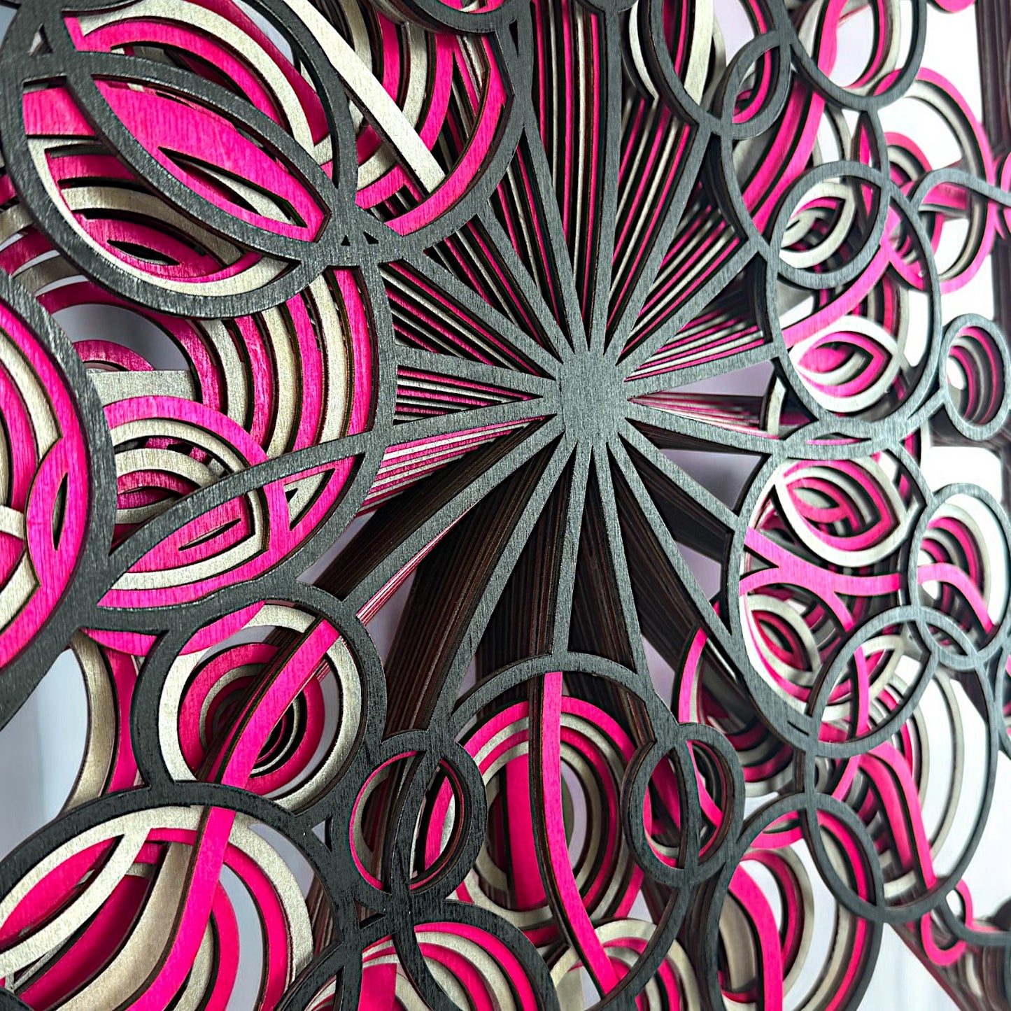 Close-up of the center, focusing on the radiating black lines and overlapping pink and cream loops that build the spiral effect.