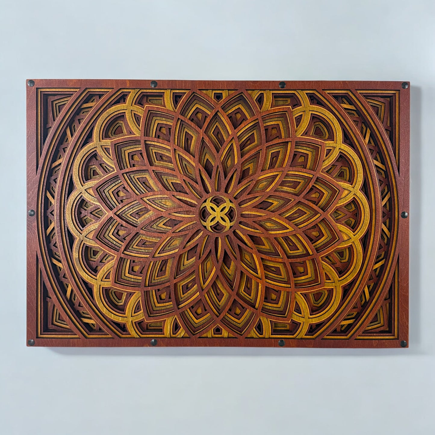Front view of an 11-layer geometric mandala wood wall art piece in warm crimson, gold, and ember tones, mounted horizontally.
