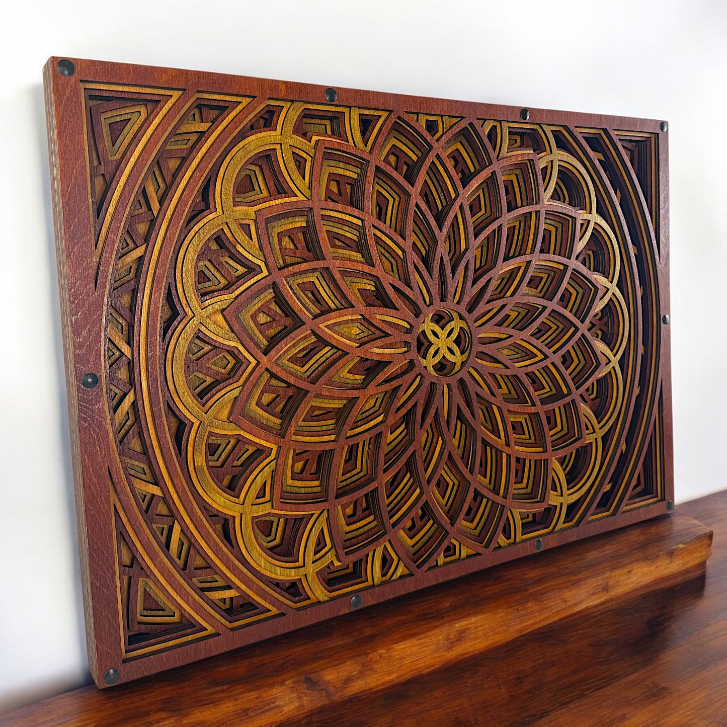 Three-quarter view of the artwork resting on a wooden surface, showcasing the natural wood grain and precise laser cuts.