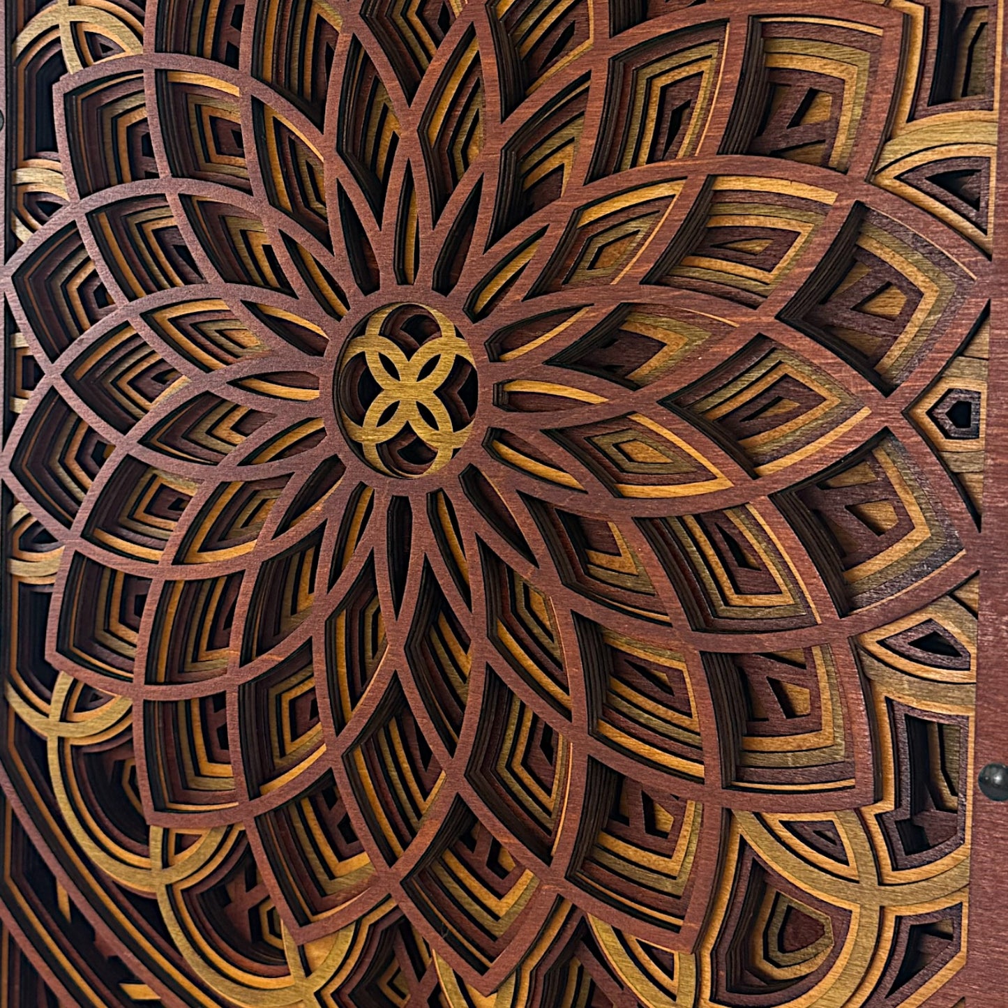 Close-up of the center of the mandala pattern, focusing on the interlocking circular design and vivid wood dye transitions.