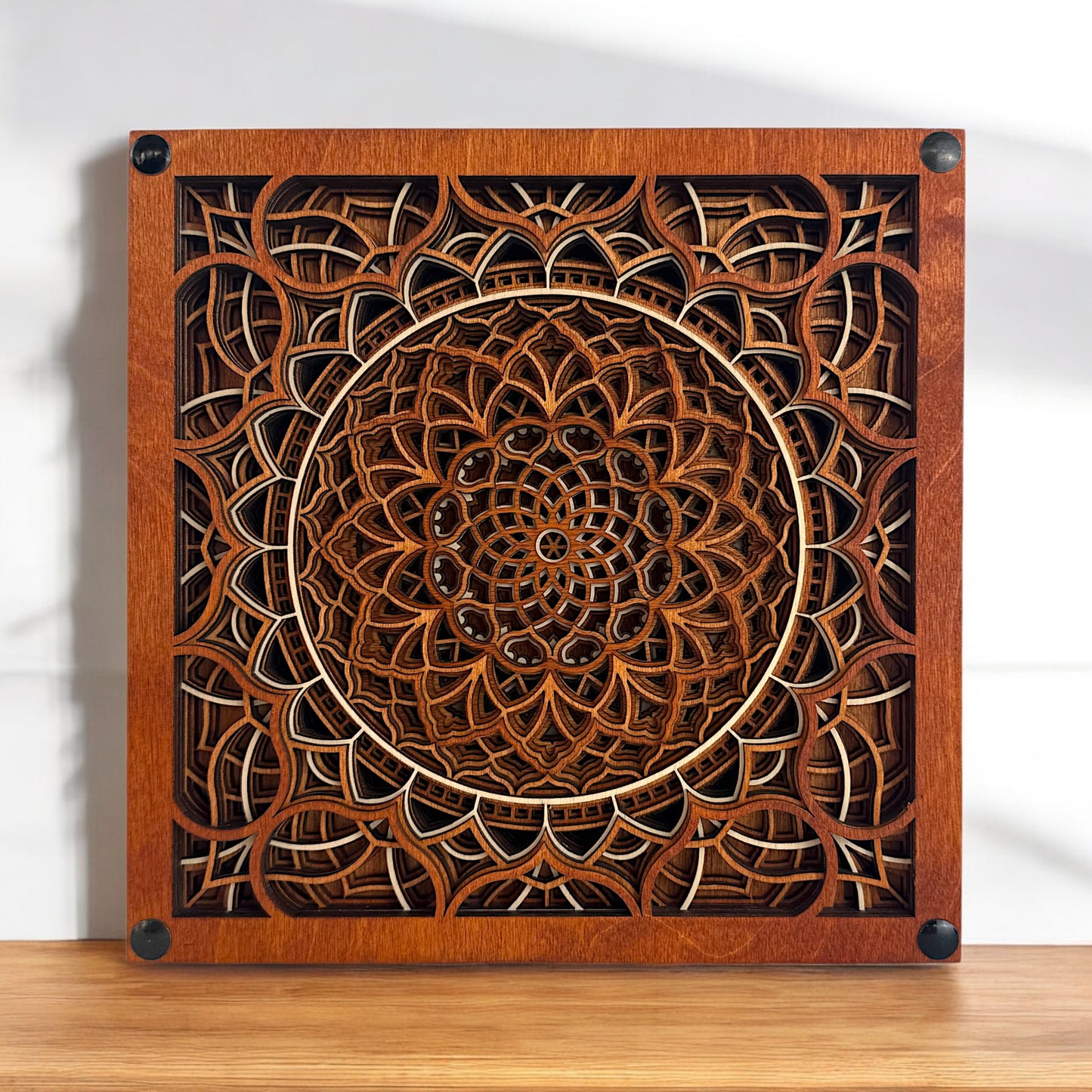 Vortex Reliquary displayed flat on a tabletop with soft sunlight, revealing its symmetrical and ornate wooden pattern.