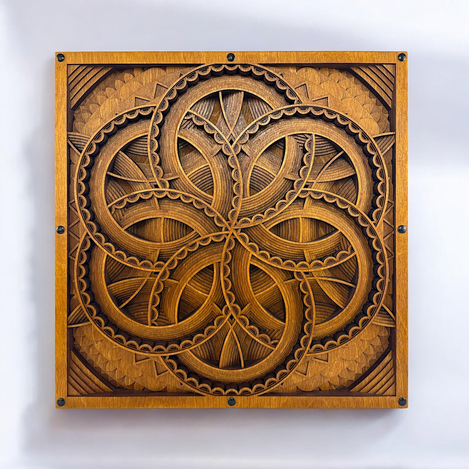 Front-facing view of Axis Reverie, a 10-layer laser-cut geometric wood art piece with interwoven circular patterns and a warm, golden-brown finish.