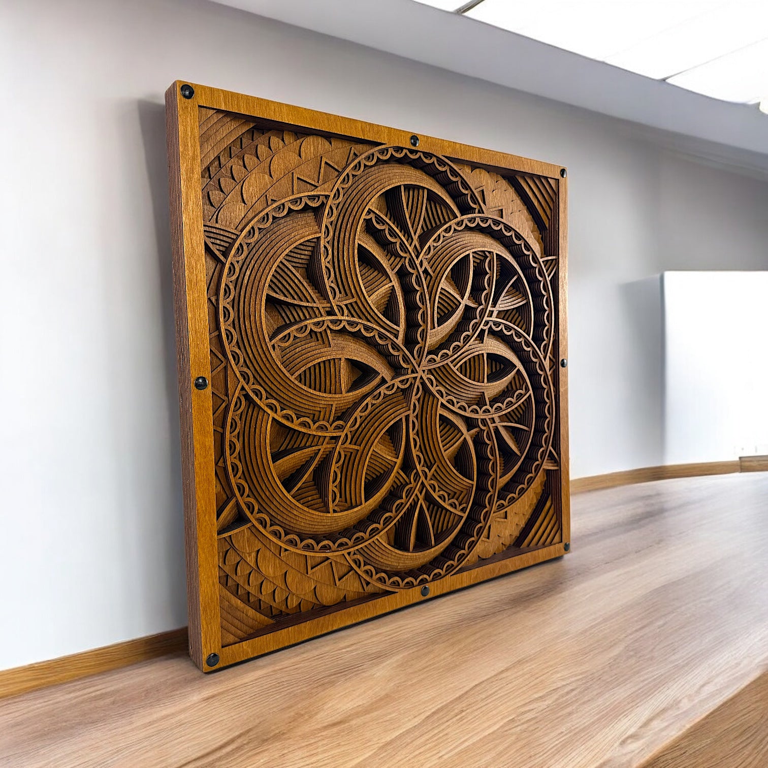 Axis Reverie wall art displayed on a wood table against a white wall, emphasizing its square format and handcrafted detail.