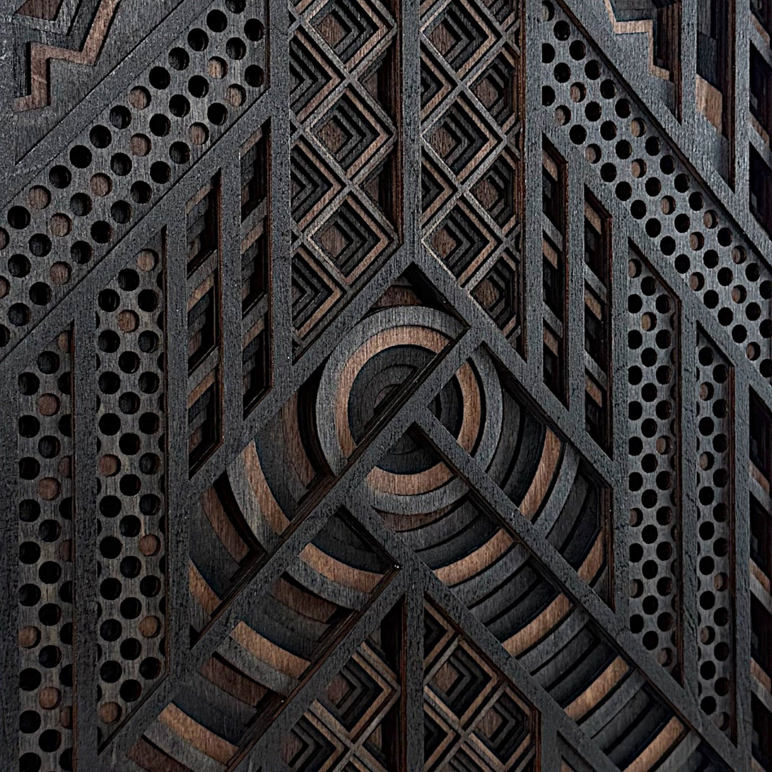 Close-up of the central section of a layered wood wall art piece, emphasizing the crisp laser cuts, concentric arcs, and fine diamond gridwork.