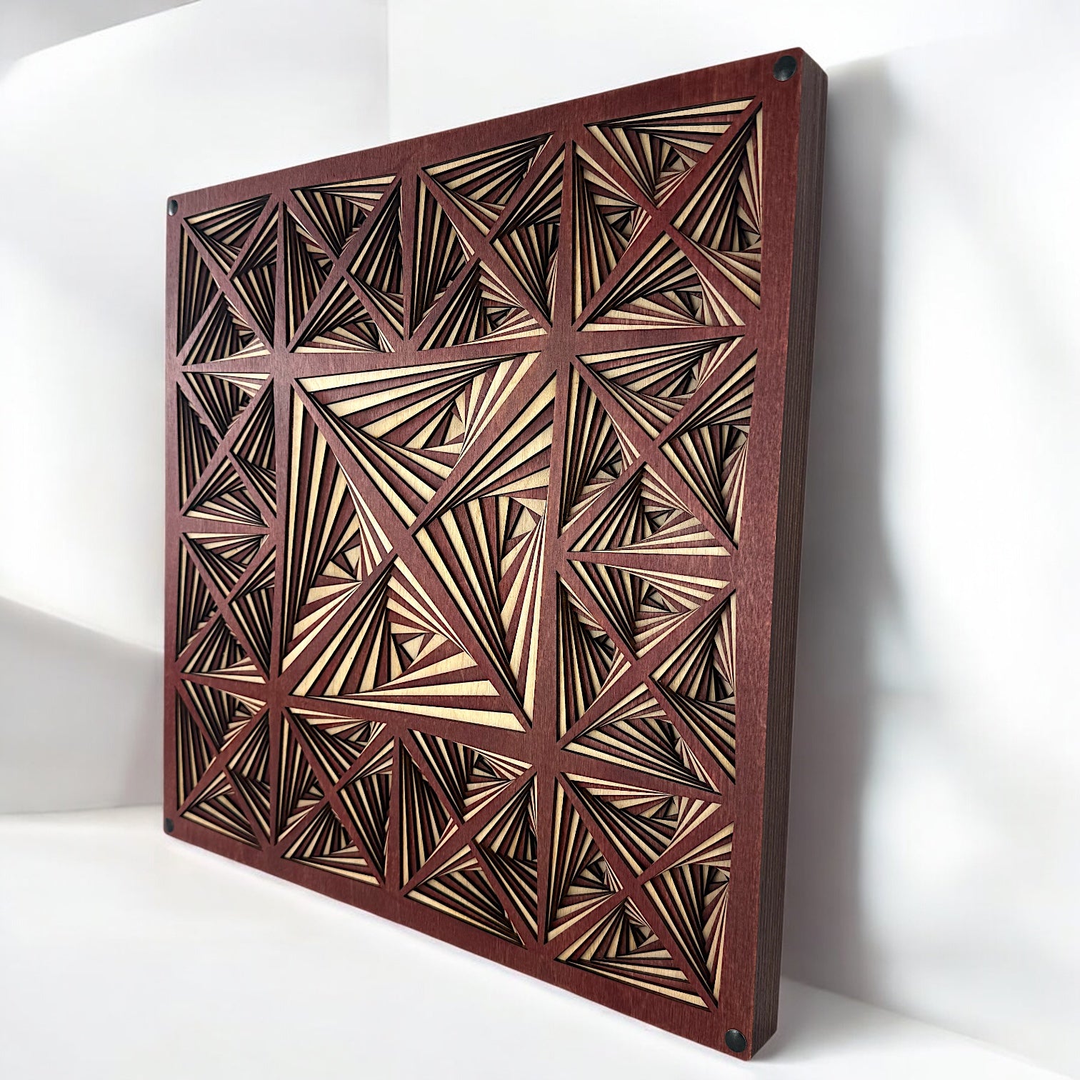Diagonal perspective showing the full layered structure of the artwork and the contrast between light and dark wood cuts.
