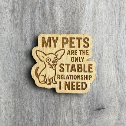 Laser-engraved wooden magnet with the same phrase, “MY PETS ARE THE ONLY STABLE RELATIONSHIP I NEED,” but with a wide-eyed, happy Chihuahua illustration sitting to the left. The magnet shape wraps around the dog and text.