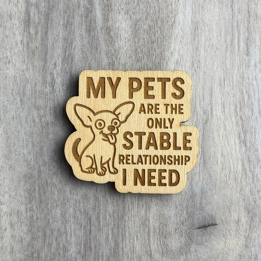 Laser-engraved wooden magnet with the same phrase, “MY PETS ARE THE ONLY STABLE RELATIONSHIP I NEED,” but with a wide-eyed, happy Chihuahua illustration sitting to the left. The magnet shape wraps around the dog and text.