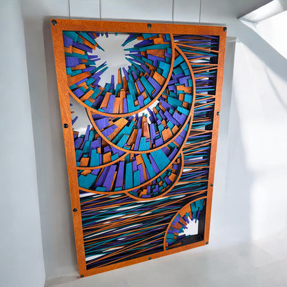 Slightly top-down view of the large wood art piece mounted on a white wall, highlighting its intricate geometric spirals and vibrant stained wood details.