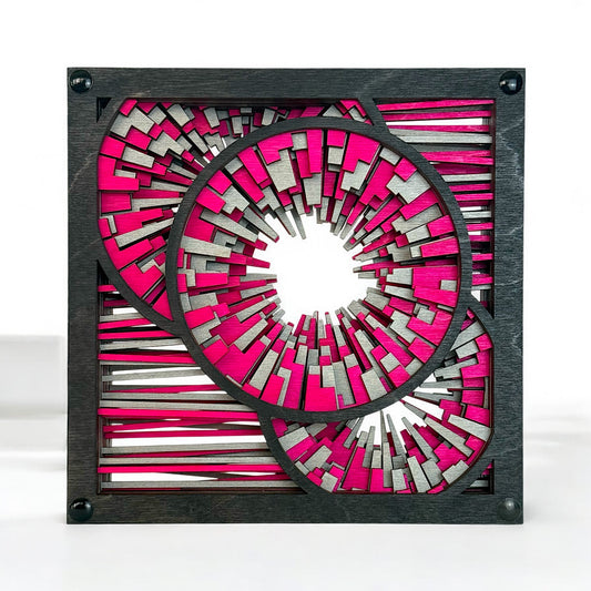 Front-facing view of Metrorhythm V2 sculpture in magenta and silver, featuring layered circular bursts and geometric lines.