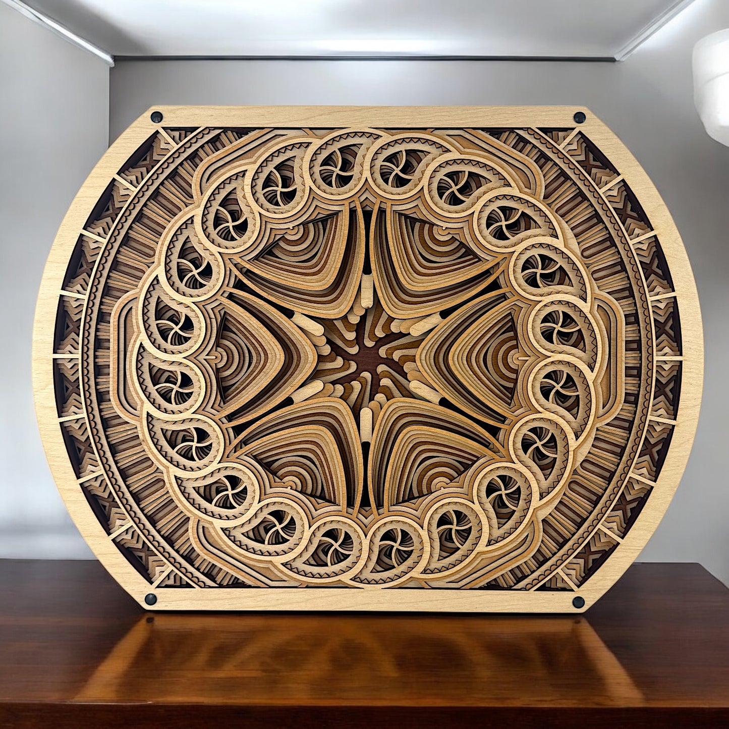 The Solar Bloom art displayed on a wooden surface, capturing its unique curved frame and starburst pattern in a natural light setting.