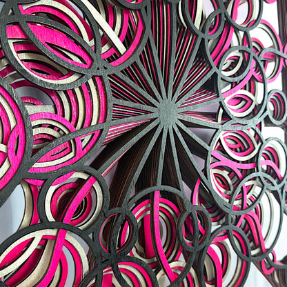 Close-up of the center, focusing on the radiating black lines and overlapping pink and cream loops that build the spiral effect.