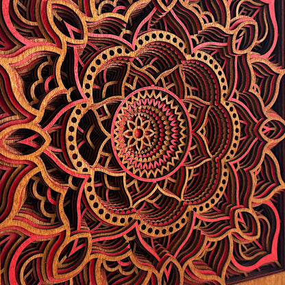 Angled macro shot of Temple Bloom mandala art showing laser precision and stacked layers in vivid red and amber tones.